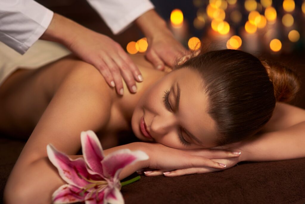 A professional massage therapist at MOssage Therapeia in Beverly Hills assisting a client with a guided stretch on the massage table, highlighting the synergy of stretching vs. massage for optimal mobility.